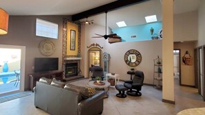 Amplia sala de estar con chimenea, televisión y un espacio de descanso confortable.