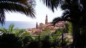 Un pueblo costero con una imponente torre de iglesia, exuberante vegetación y una vista despejada del mar.