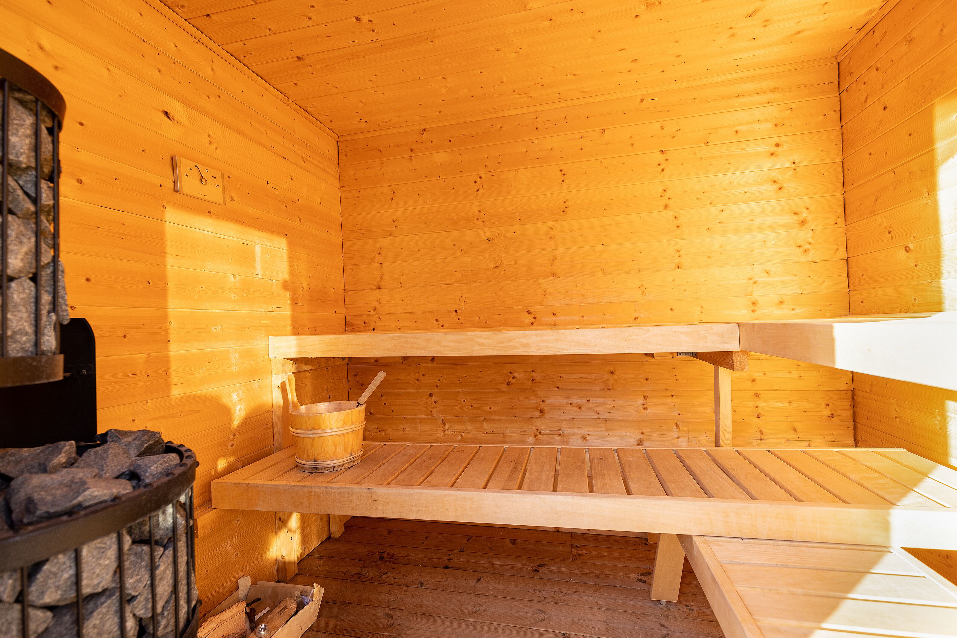 A sauna room with wooden walls and benches.