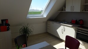 A kitchen with a skylight, a dining area with a table and chairs, and a view of the outdoors.