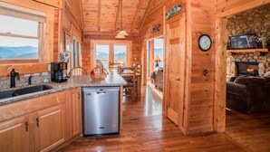 Interior de una cabaña de madera con cocina, comedor y sala de estar.