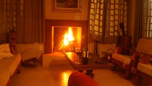 Una sala de estar acogedora con chimenea, un sofá, una mesa de centro y una lámpara.