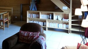 A cozy room with a wooden ceiling, a staircase, a bookshelf, and a sofa. - Chalet on the slopes in Valmeinier 1800 (Valmeinier)