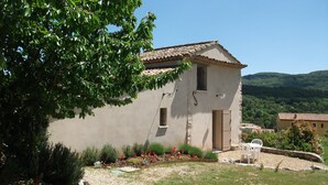 A rustic building with a tiled roof, surrounded by a garden with various plants and flowers. -  BASTIDON, POOL, 3000 M2 OF LAND, 2-4 PERS, APT, Luberon (Apt)