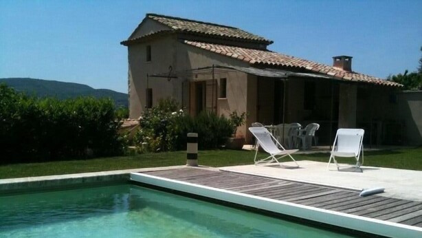A swimming pool with two lounge chairs and a building with a tiled roof. -  BASTIDON, POOL, 3000 M2 OF LAND, 2-4 PERS, APT, Luberon (Apt)