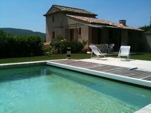 A swimming pool with two lounge chairs and a building with a tiled roof. - BASTIDON, POOL, 3000 M2 OF LAND, 2-4 PERS, APT, Luberon (Apt)