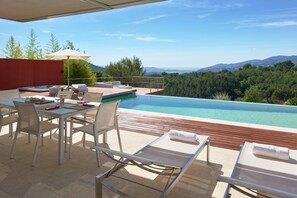 Una piscina al aire libre, una piscina climatizada, tumbonas