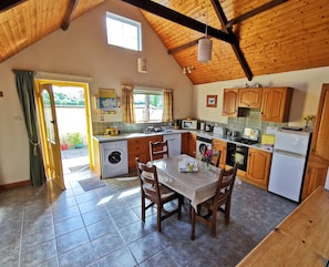 Spacious kitchen/diner with door to private south-facing patio, seen from lounge