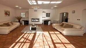 Un salon spacieux avec deux canapés placés face à face, une table basse au centre et une cheminée.