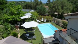 A swimming pool surrounded by a garden with various plants and outdoor furniture. - If you like peace and quiet between sea and mountains (Zonza)
