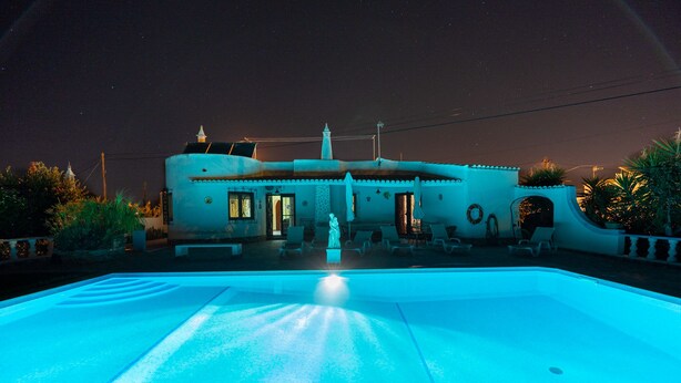 A swimming pool with a unique architectural design, a statue in the center, and a night sky. - Villa 10 minutes from the beach, in a very quiet location w/ private pool (Armação de Pêra)