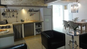 Eine moderne Küche mit Steinwand, Edelstahlgeräten und einem Essbereich mit einer Chandelier.