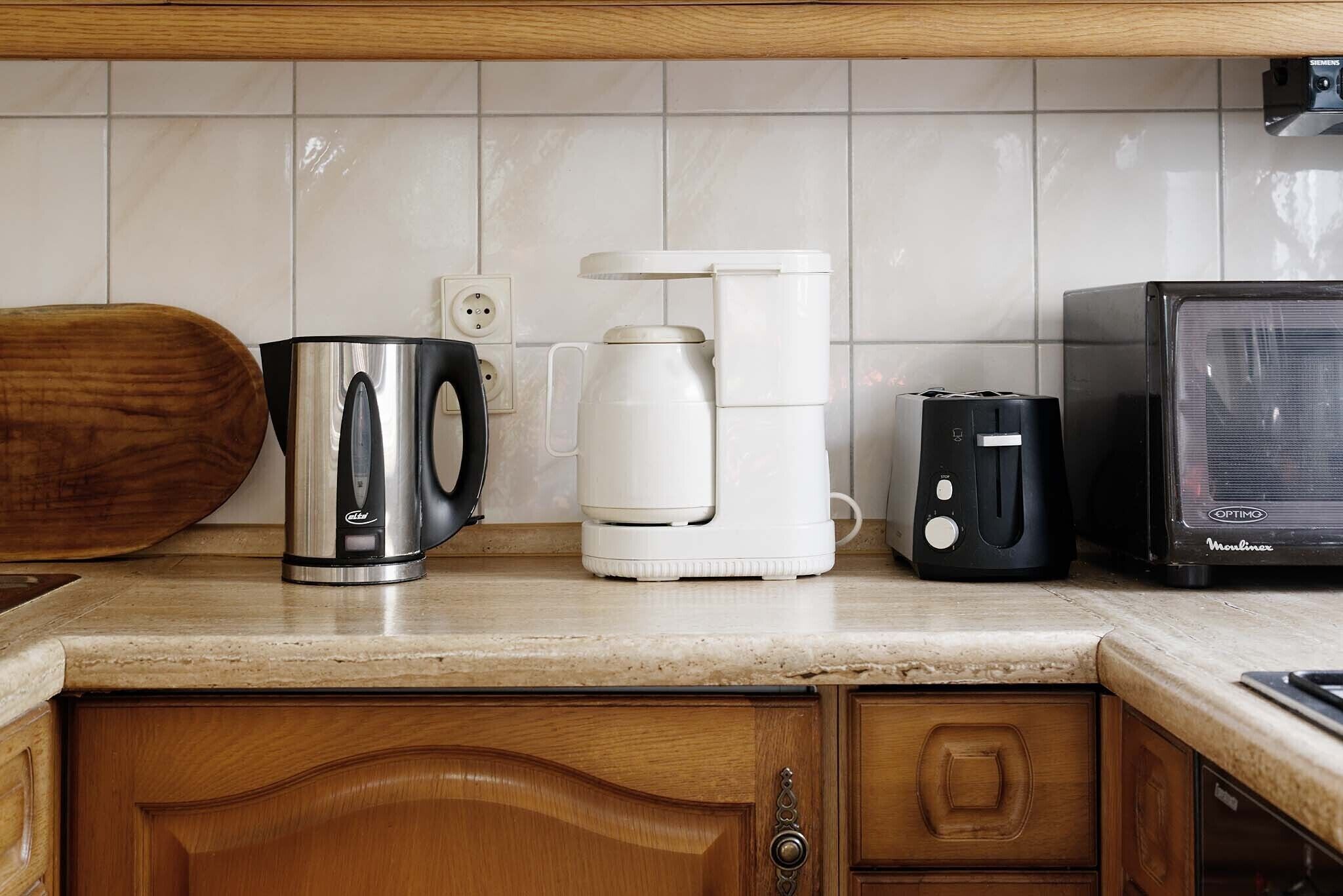 A kitchen with a coffee maker, toaster, and microwave on the counter.