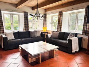 A living room with two sofas, a coffee table, and a chandelier.