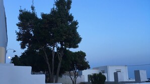 A modern building with a white facade, a tree in front, and a clear blue sky. - Artemonas: House with character (Artemonas)