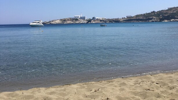 A beach with clear blue water, a sandy shore, and a few boats. - Artemonas: House with character (Artemonas)