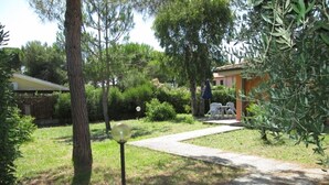 Um caminho no jardim leva a um edifício com área de estar ao ar livre.