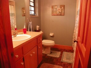 A bathroom with a sink, toilet, and a small window. - Peaceful Country Style Home with access to lakes ready to fish large mouth bass. (Lakeland)