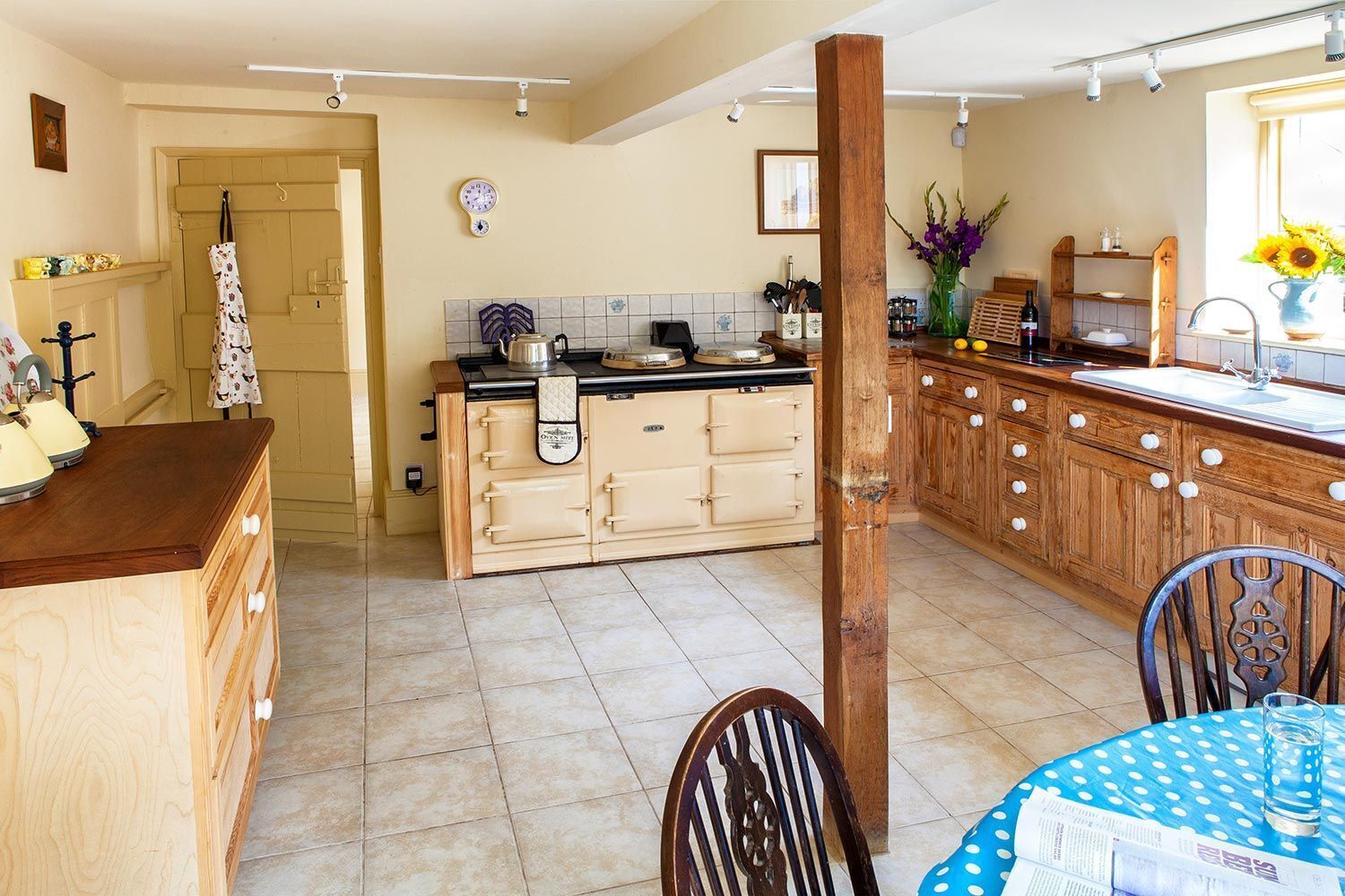 A kitchen with wooden cabinets, a central island, and a dining area with a table and chairs.