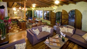 A spacious living area with a wooden ceiling, a bar area, and large windows offering views of the outdoors. - 6BR Luxury Ocean View Villa • 3 Private Pools • Chef Included • Sky Deck (Manuel Antonio)