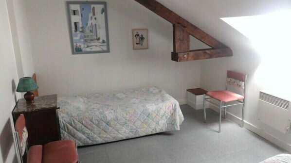 A bedroom with a bed, a chair, a small table, and a picture on the wall. - House for rent Dinard Saint-Enogat (Dinard)