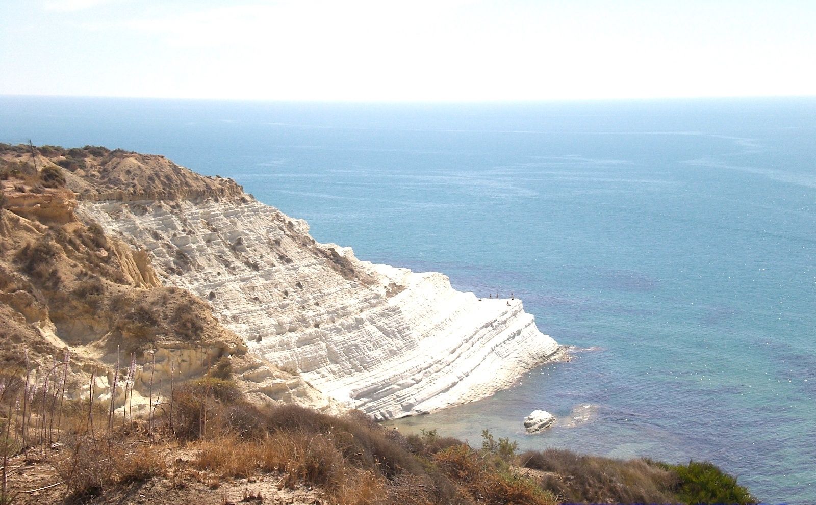 A coastal landscape with white cliffs and a view of the sea.