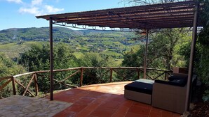 A covered outdoor seating area with a view of terraced vineyards. - Independent villa in the panoramic countryside (Greve In Chianti)
