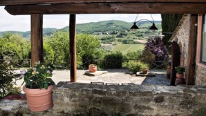 A stone balcony with terracotta pots, wooden beams, and a view of rolling hills and vineyards. - Independent villa in the panoramic countryside (Greve In Chianti)
