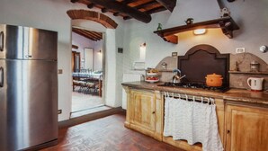 A kitchen with a stainless steel refrigerator, wooden cabinets, and a tiled backsplash. - Independent villa in the panoramic countryside (Greve In Chianti)