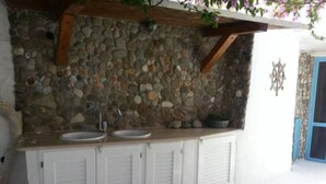 A stone wall with a sink and cabinets. - The house by the sea one step away from the beach (ponza)