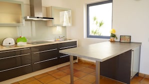 A modern kitchen with a large window, a built-in oven, and a sink.