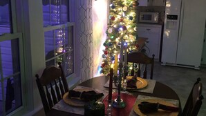A dining area with a Christmas tree, candles, and a festive table setting. - Lovely home on 136acre, 13 Miles from North Asheville.  6 miles from BR Parkway (Weaverville)