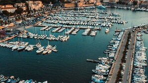 An aerial view of a marina with numerous boats docked, a road running alongside, and buildings in the background. - 100 meter from the sea, nice apartment in centre of Alghero with terrace  (Alghero)