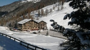 A ski resort with a multi-story building, ski lifts, and a snow-covered landscape. - Luxurious and large apartment (103 m²) at 1,735 m with underground parkin (Haute Nendaz / Siviez)