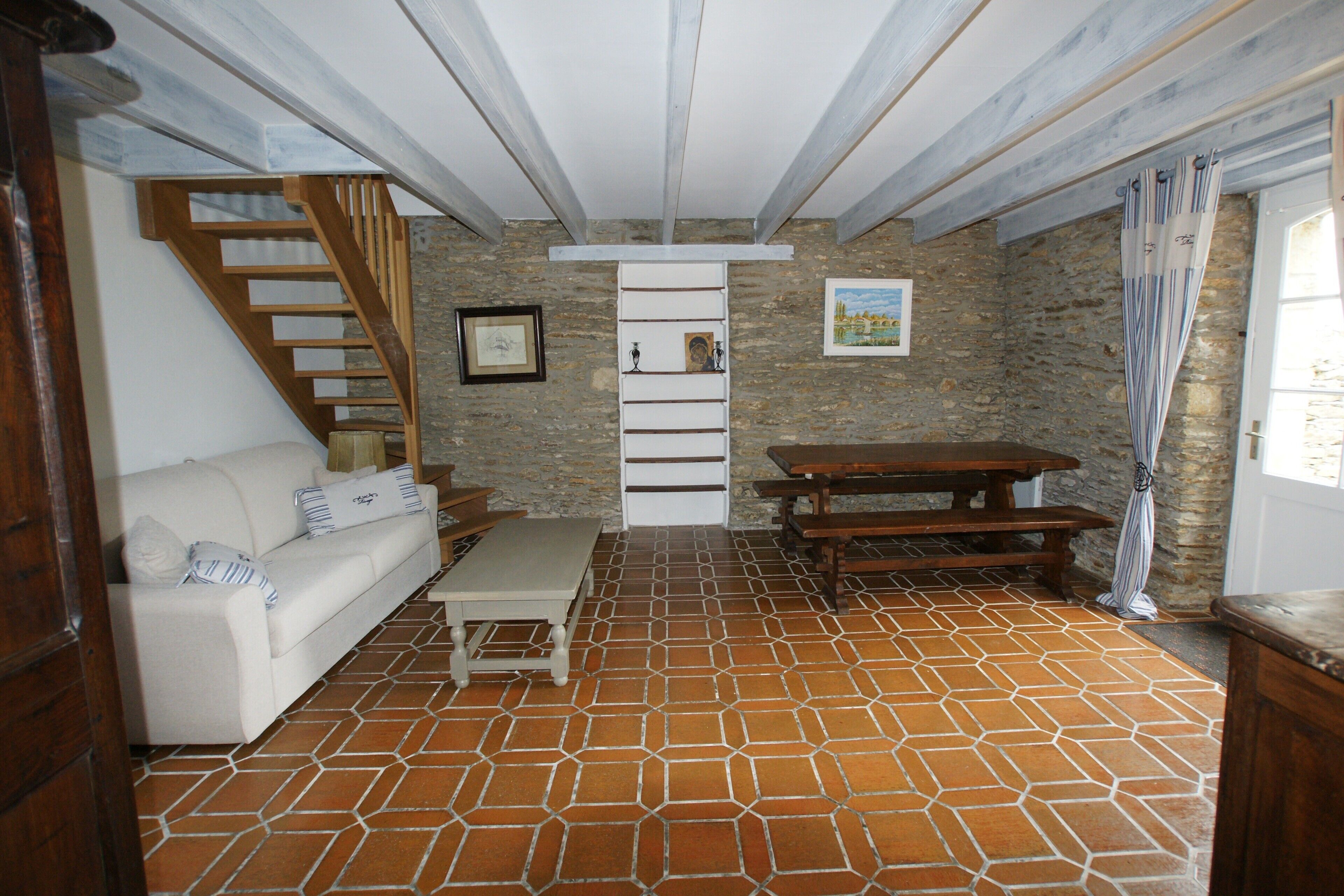 Un salon chaleureux avec un canapé, une table en bois et un escalier.