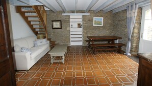 Una sala de estar acogedora con un sofá, una mesa de madera y una escalera.