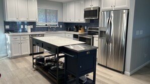 A modern kitchen with white cabinets, stainless steel appliances, and a central island. - What a Great Escape for Families  and Friends!   Private Slip! (Lake Nacimiento)