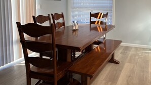 A dining room with a wooden table, four chairs, a bench, and a ceiling light fixture. - What a Great Escape for Families  and Friends!   Private Slip! (Lake Nacimiento)