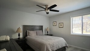 A bedroom with a bed, a nightstand, a lamp, a ceiling fan, and a window with blinds. - What a Great Escape for Families  and Friends!   Private Slip! (Lake Nacimiento)