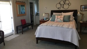 A bedroom with a large bed, a bench, a desk, and a chair. There is a mirror on the wall and a picture frame. - Vineyard Guest House, Fabulous Views and Covered Parking (Paso Robles)