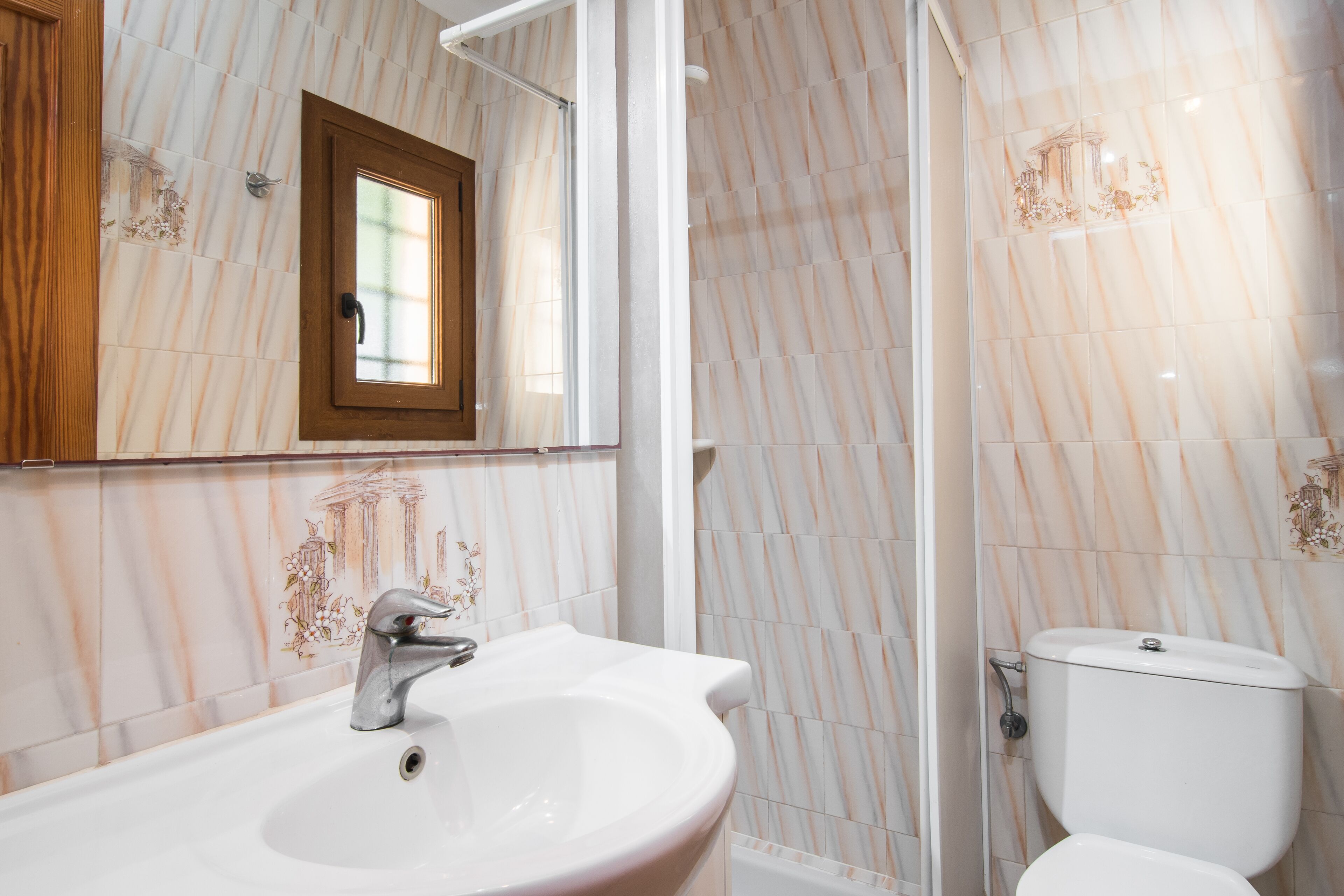 A bathroom with a marble backsplash, a sink with a modern faucet, and a toilet.