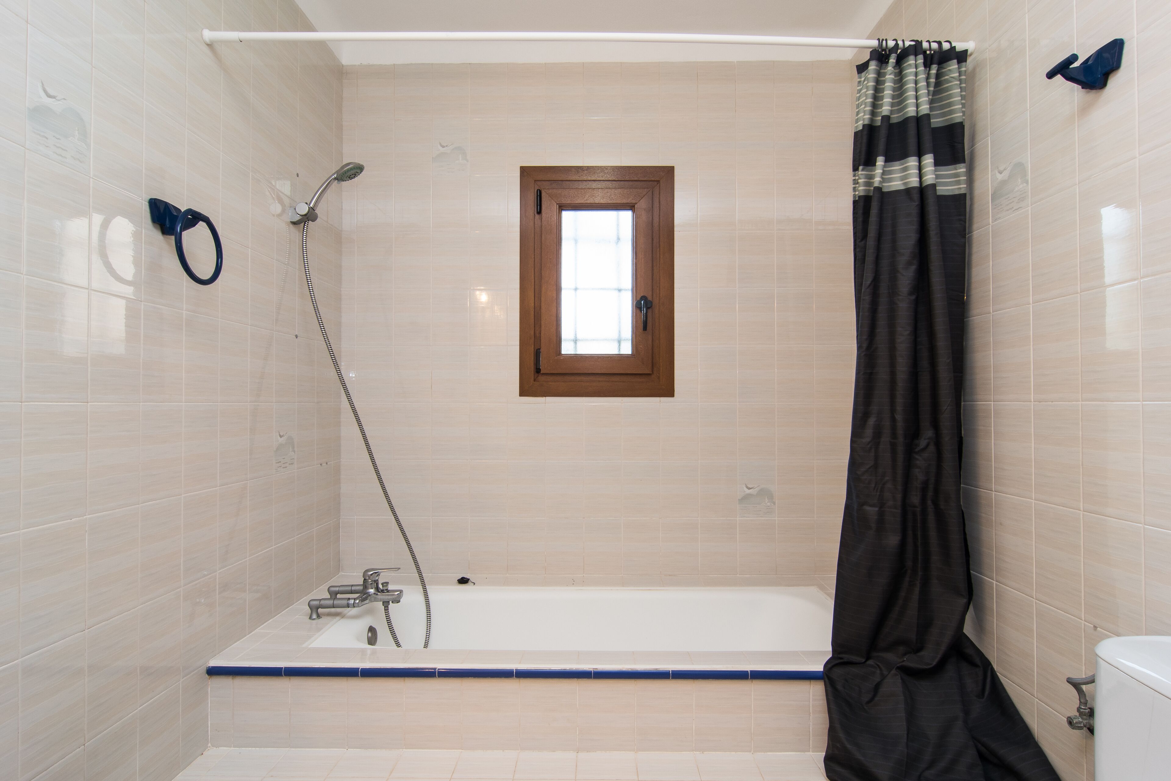 A bathroom with a bathtub, shower, and a window.
