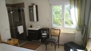 A hotel room with a bed, a bathroom with a shower, a sink, and a chair. - Holiday home with private pool at the foot of the Pyrenees and near the beach (Laroque-Des-Albères)