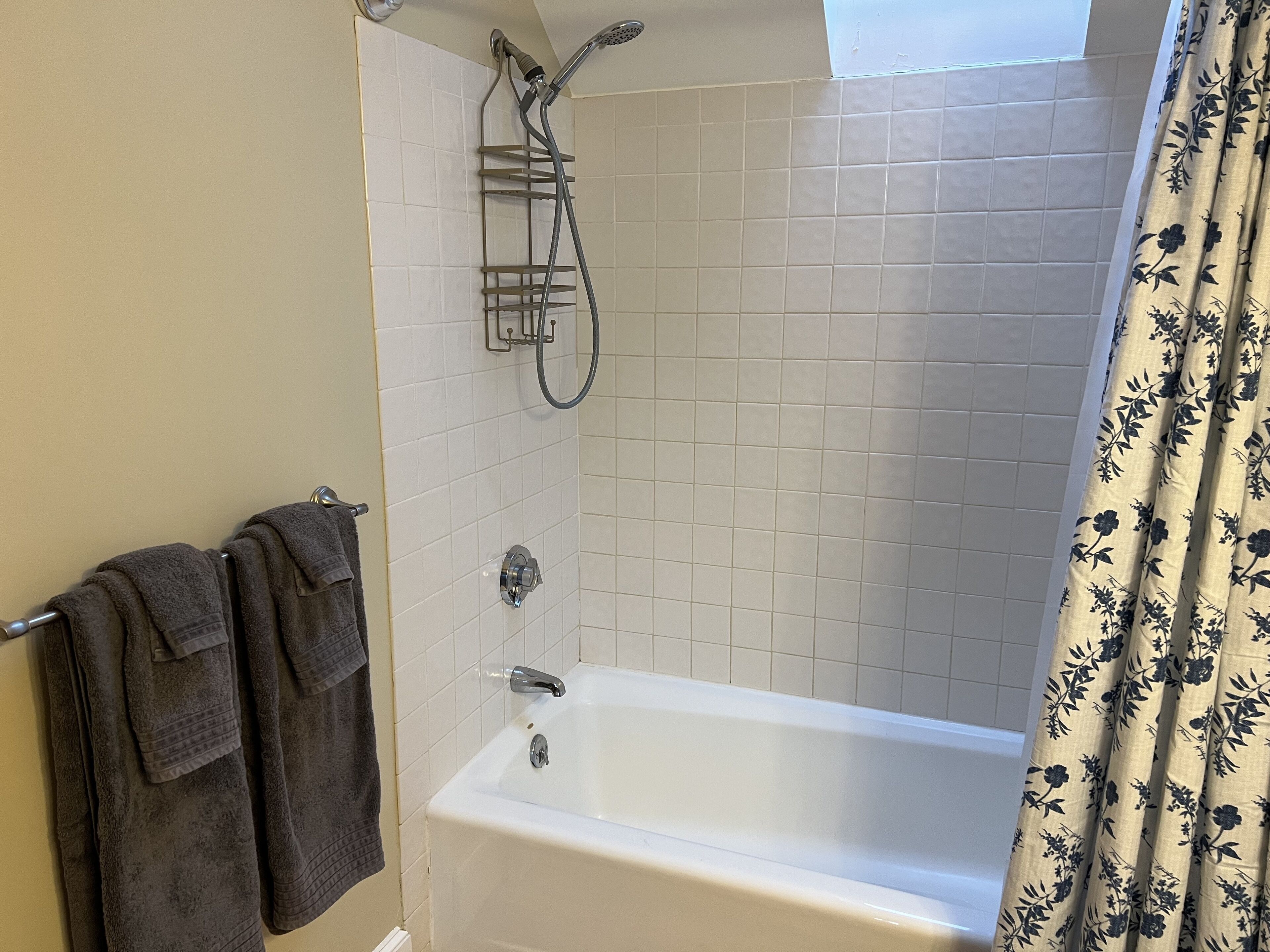 Une salle de bain équipée d’une baignoire, d’une douche et d’un porte-serviettes avec des serviettes.