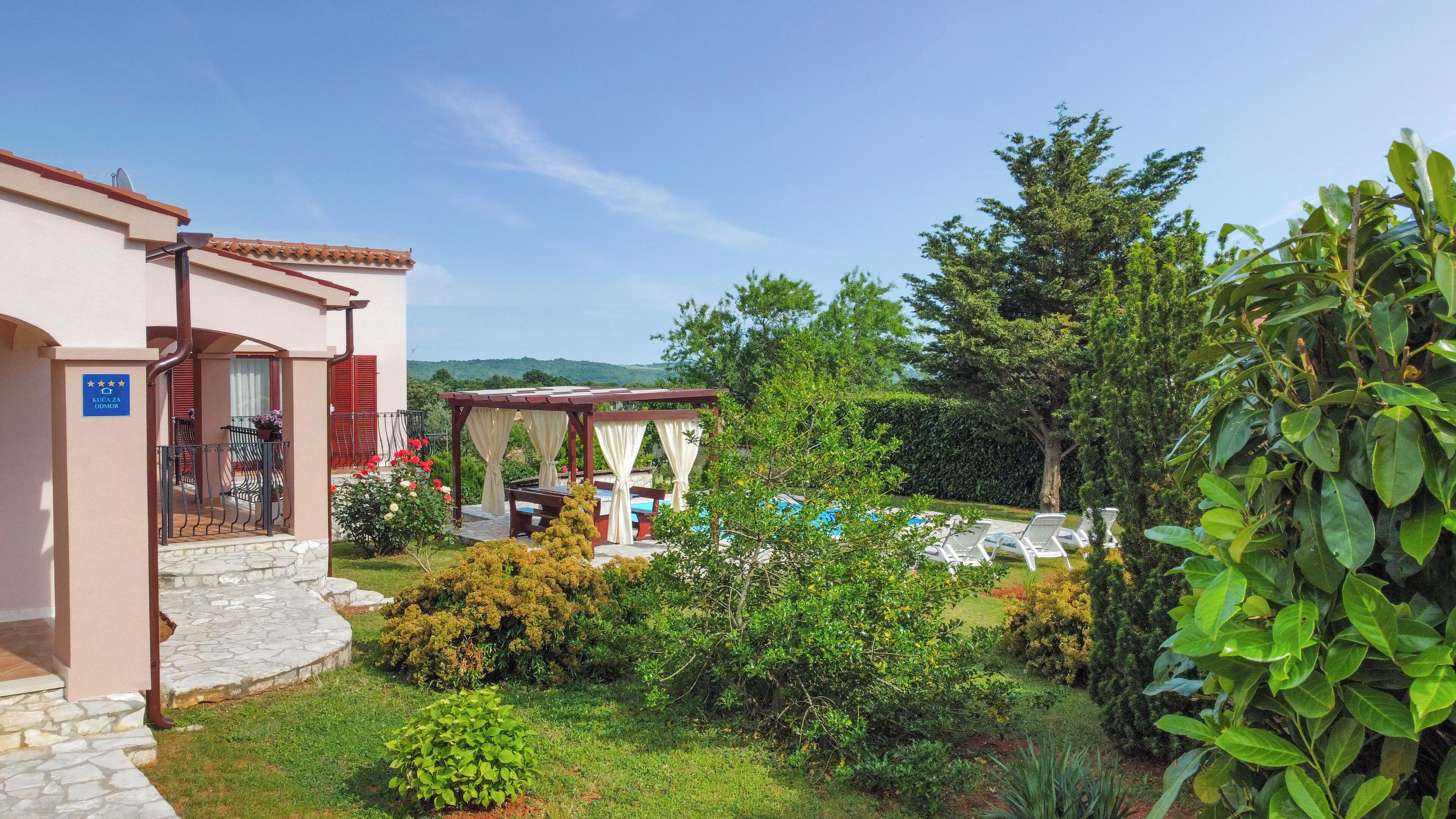 A hotel with a pool area, outdoor seating, and a garden.