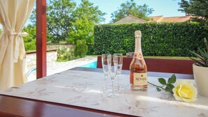 Et bord med en flaske RÖMER champagne, tre glas og en gul rose.