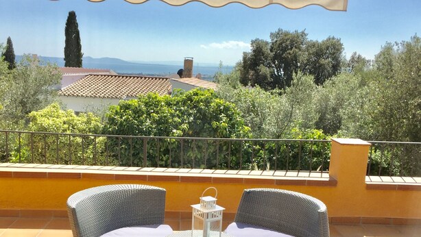 Une terrasse dotée de meubles en osier et offrant une vue sur le paysage.