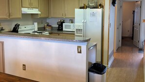 A modern kitchen with wooden cabinets, a white refrigerator, a microwave, and a stove. -  Gorgeous sunsets and lake views (Port Clinton)