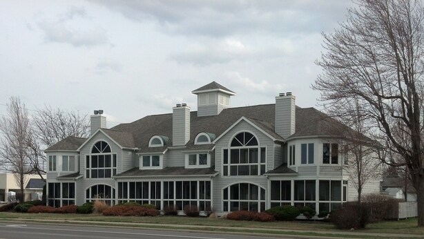 A large, two-story house with a symmetrical facade, multiple chimneys, and large windows. -  Gorgeous sunsets and lake views (Port Clinton)
