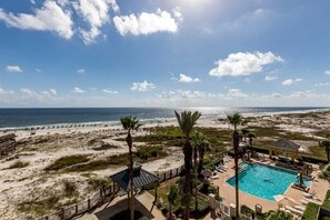 A beach resort with a swimming pool, palm trees, and a view of the ocean. - Number One Rated Resort Along Entire Coast! 5 Star Rated Unit (Gulf Shores)